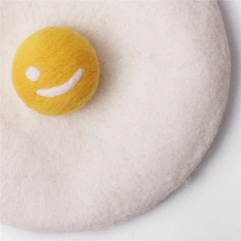 Felted fried egg with smiley face.