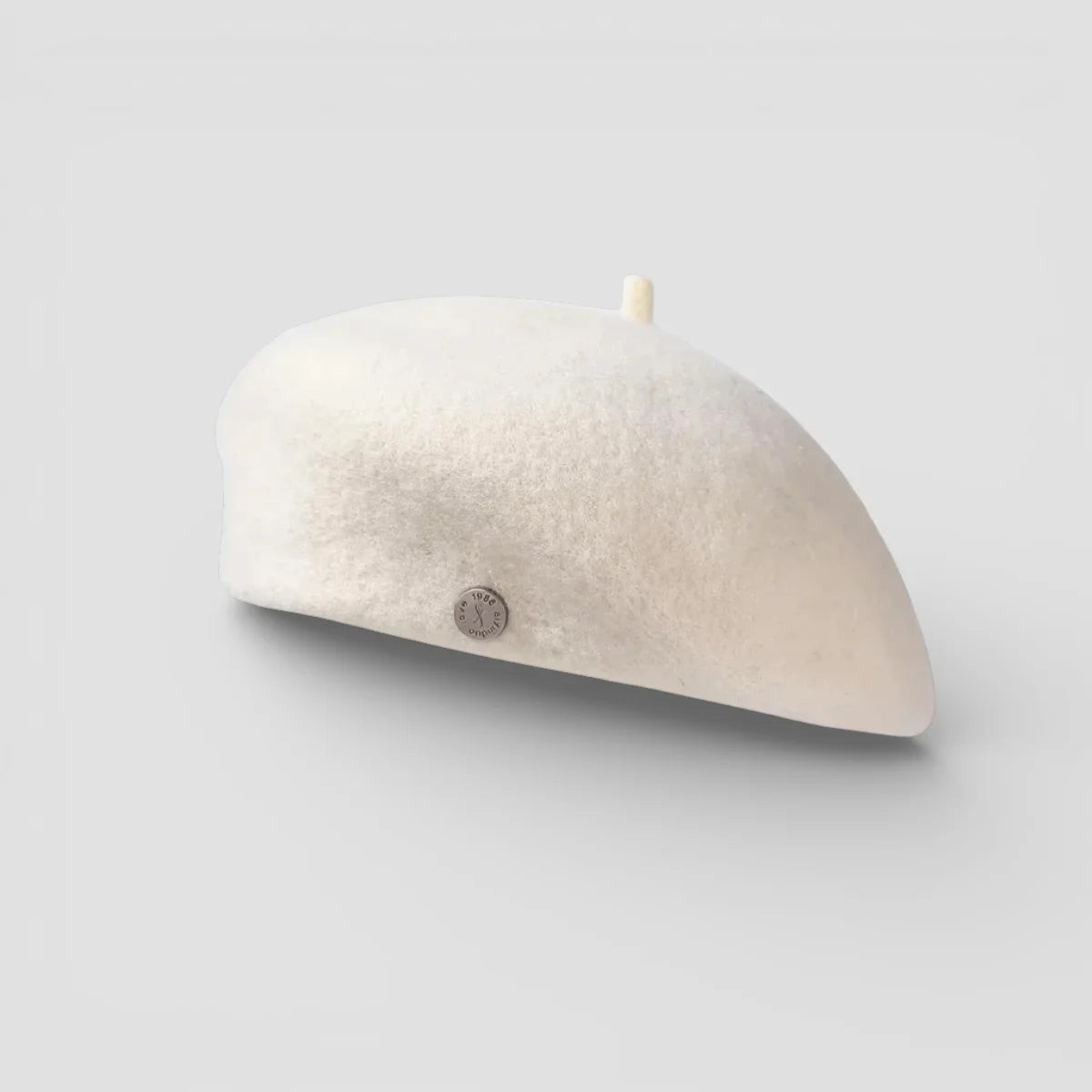 Cream-colored felted wool beret with metallic button and fabric band
