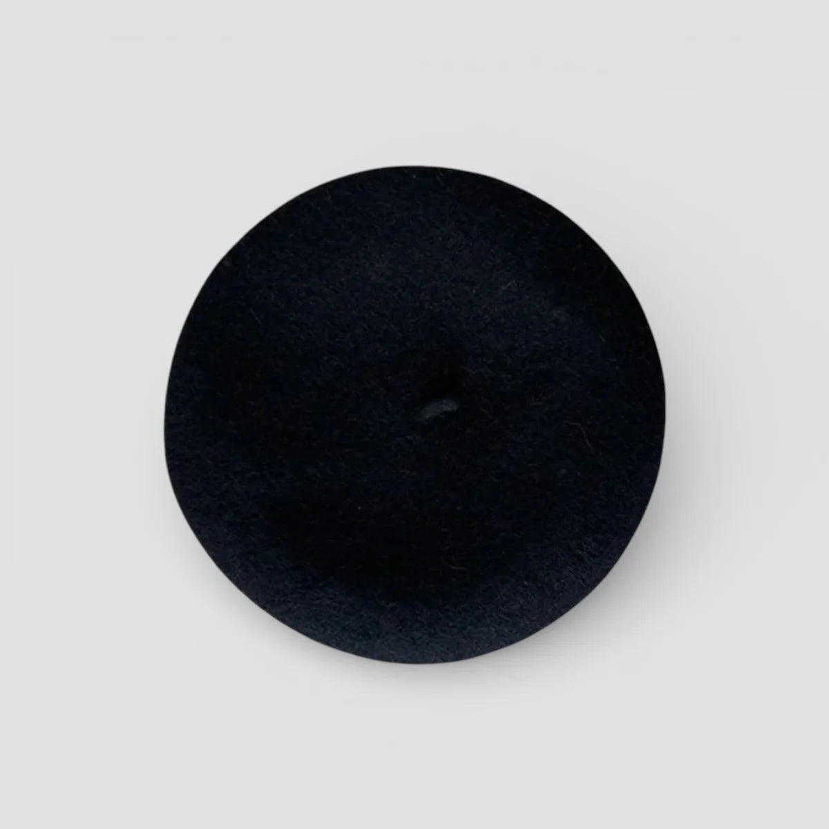 Back of Flower Beret: black matte velvety button with central hole