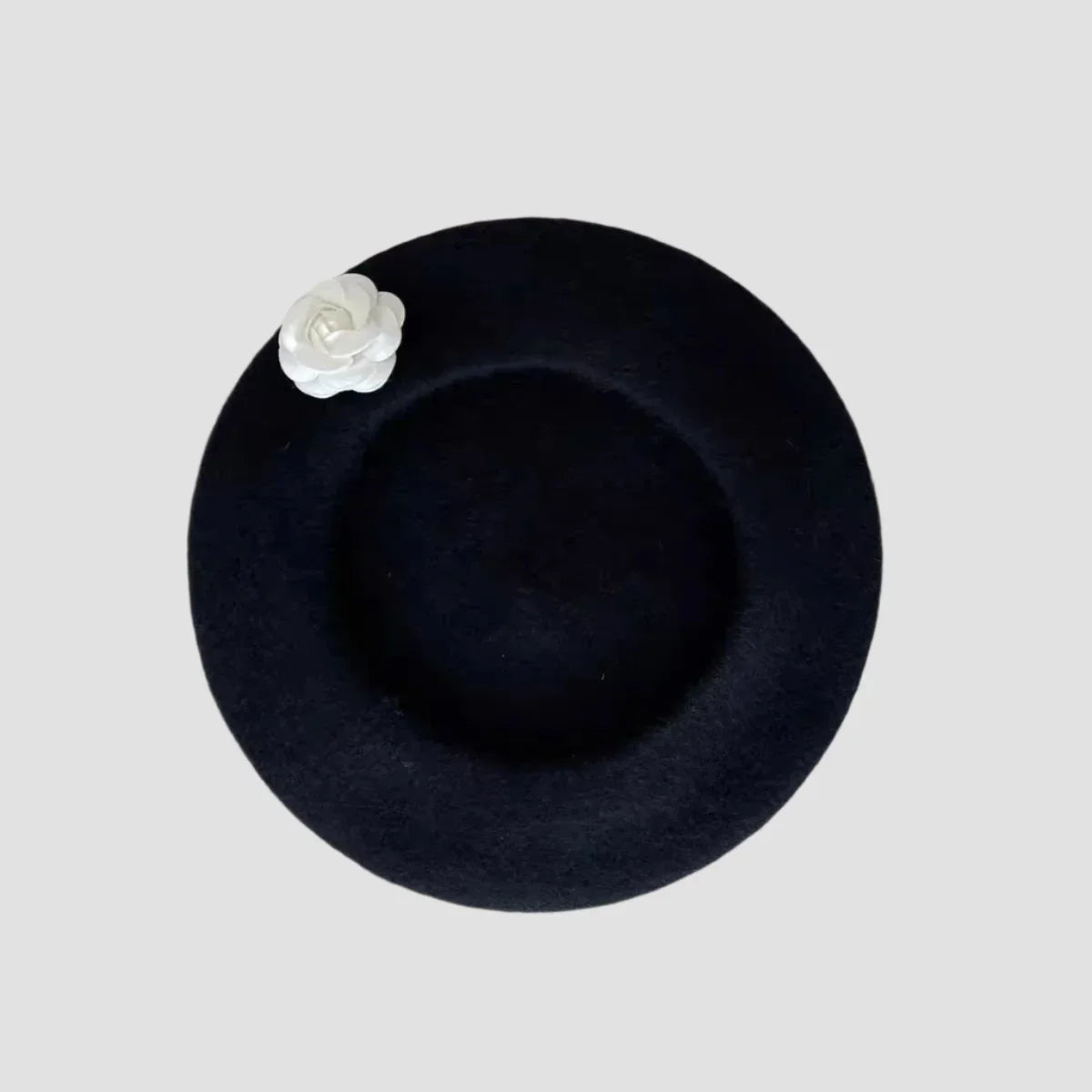 Black beret with white flower.
