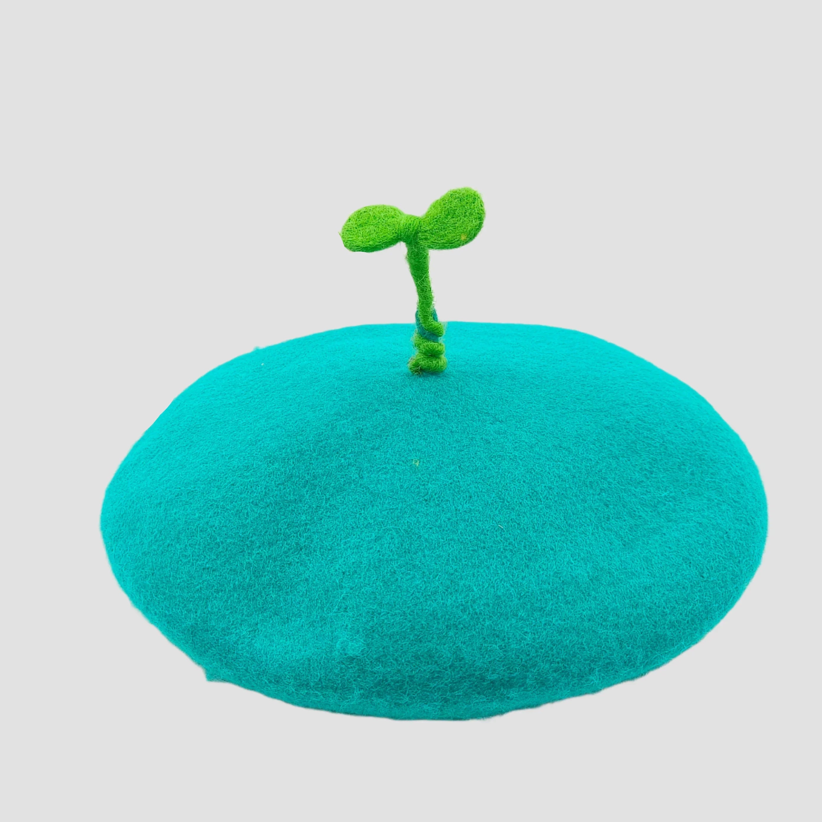Teal beret with green sprout.