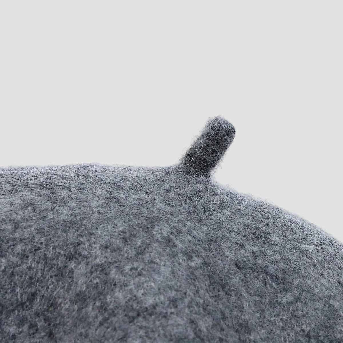 Close-up of a textured gray surface with a small raised area on a light gray background