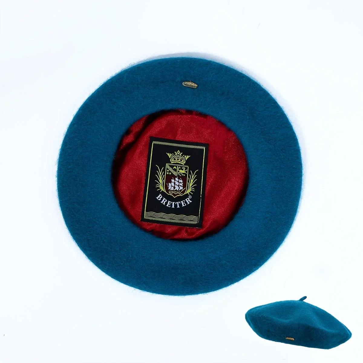 Teal Lined Beret, top view showing red satin lining and brand patch