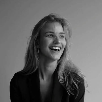 Black and white portrait of a woman with a smile on a plain background