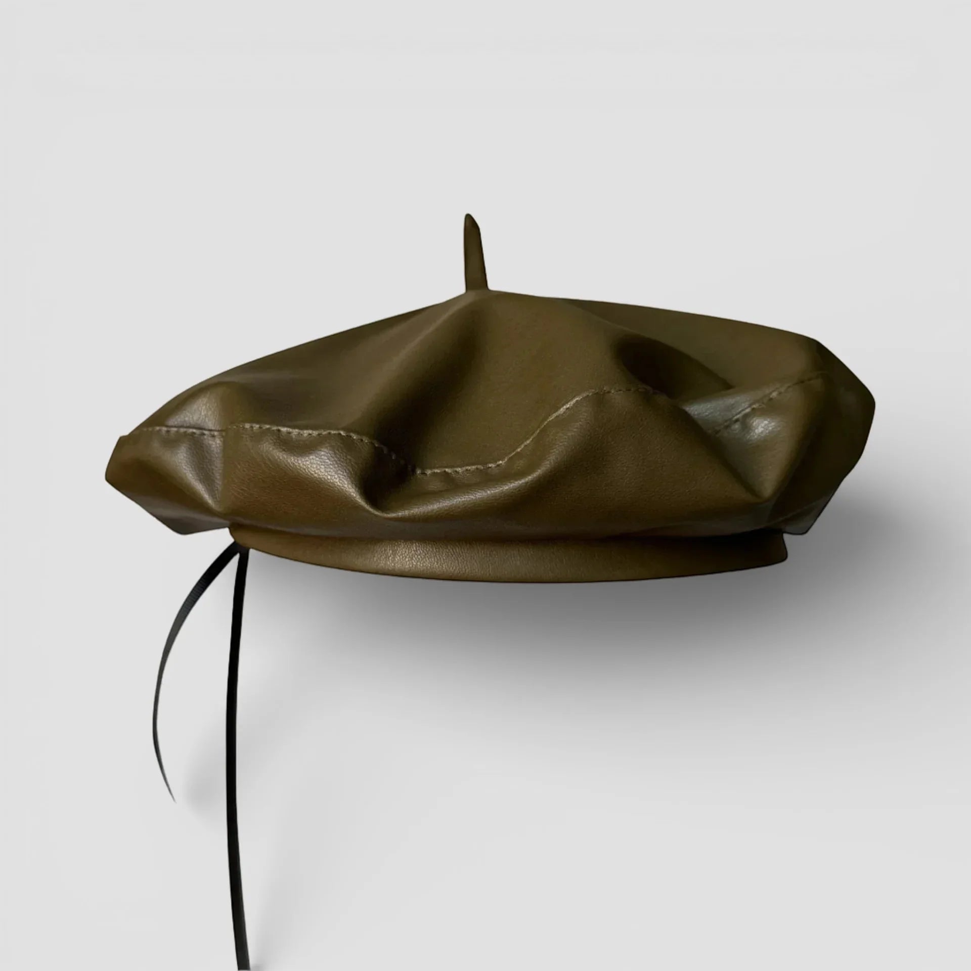 Green leather beret with olive green faux leather, central button, black strap