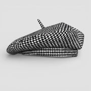Houndstooth beret in black and white with decorative tassel on top
