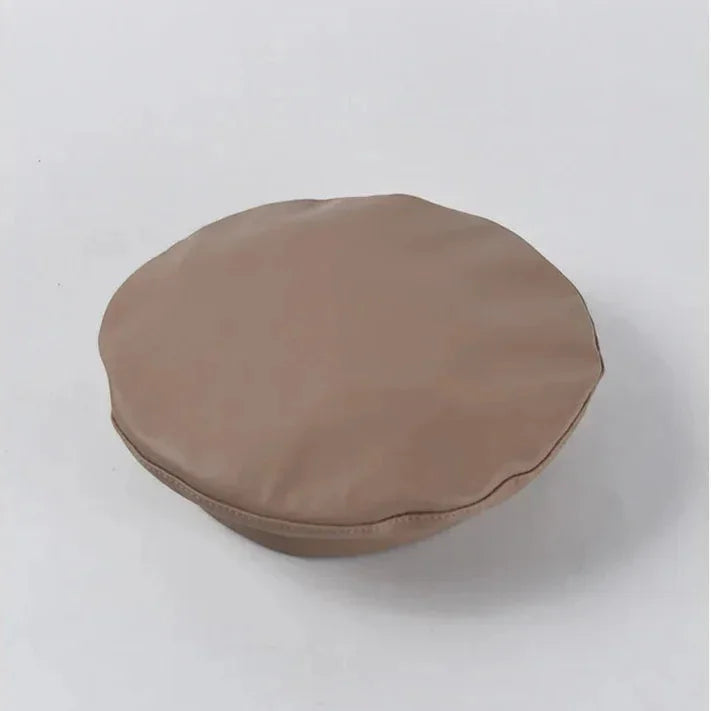 Khaki leather beret with beige circular cushion, soft padded texture and neat stitching
