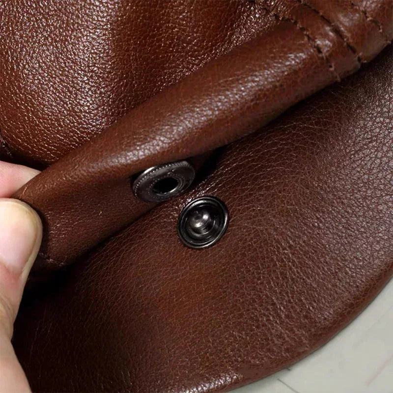 Brown leather Newsboy hat with visible stitching and metal snaps