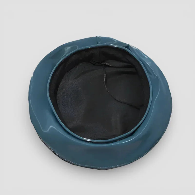 Sleek teal patent leather bucket hat with glossy finish and black lining
