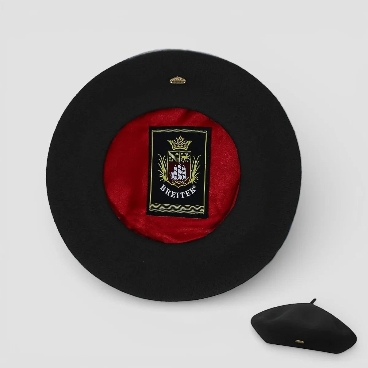 Lined beret with black felt exterior, red velvet lining, and gold Breiter crest