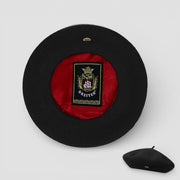 Lined beret with black felt exterior, red velvet lining, and gold Breiter crest