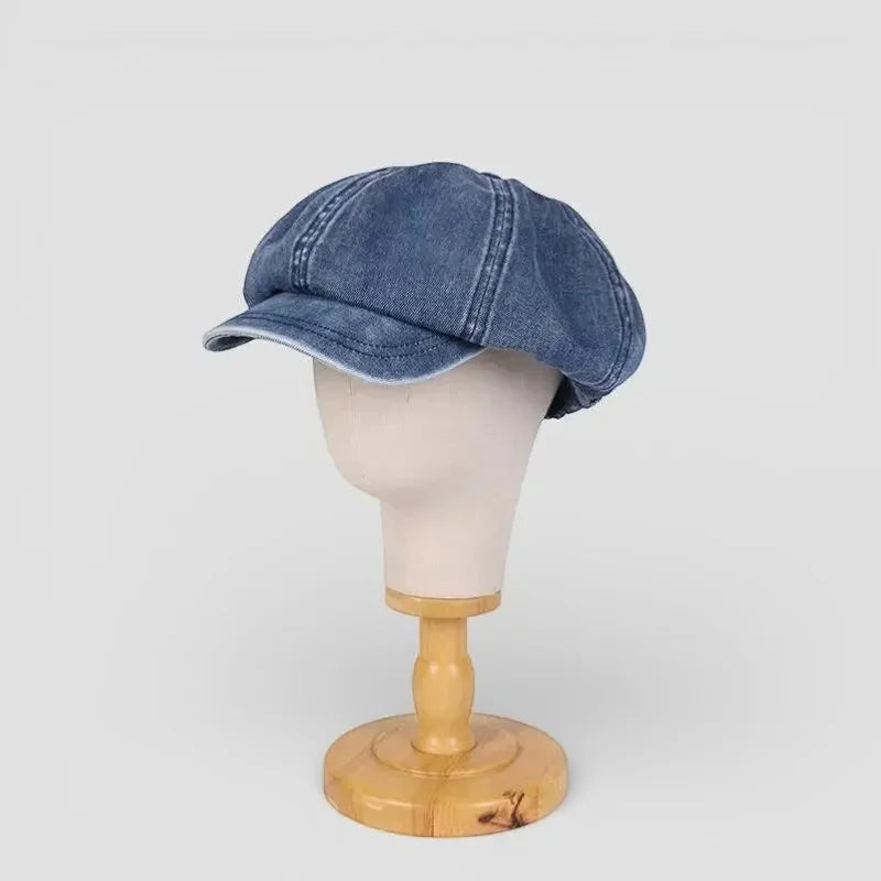 Blue denim newsboy beret flat cap with stitched seams and worn texture