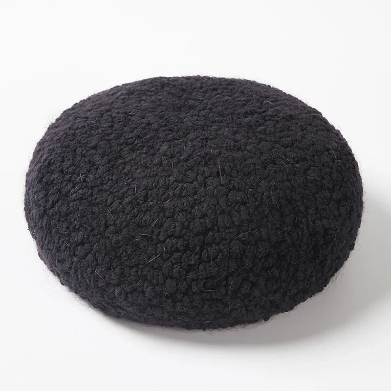 Round, black, shaggy cushion.