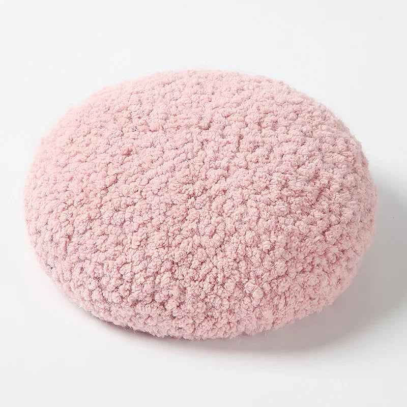 Round, pink, fluffy pillow.