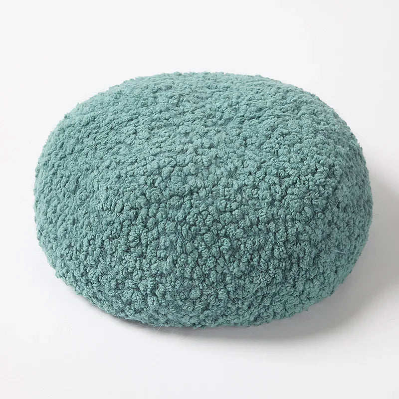 Round, textured, teal cushion.