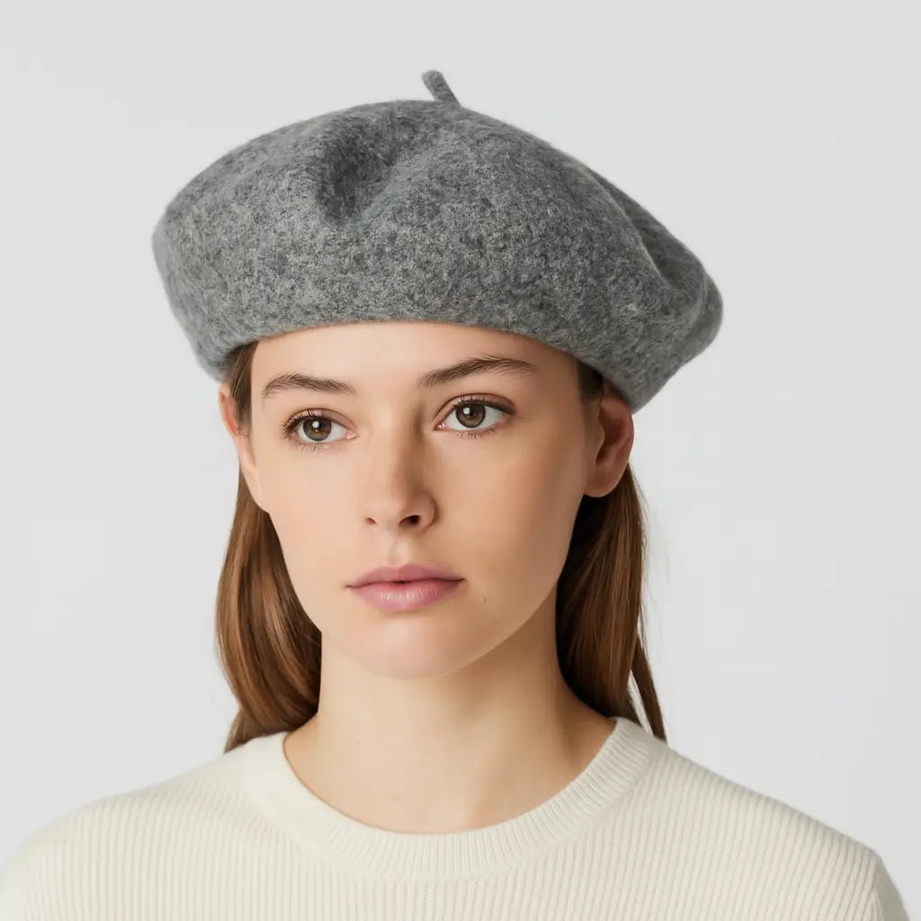 Person wearing a gray beret against a light background