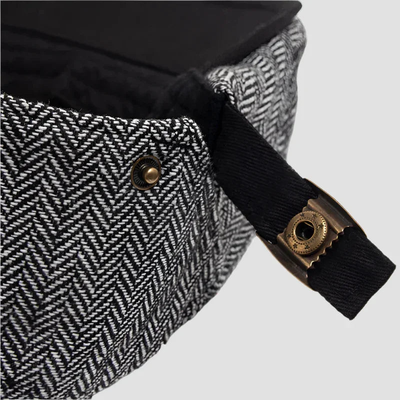 Herringbone patterned hat with black strap.