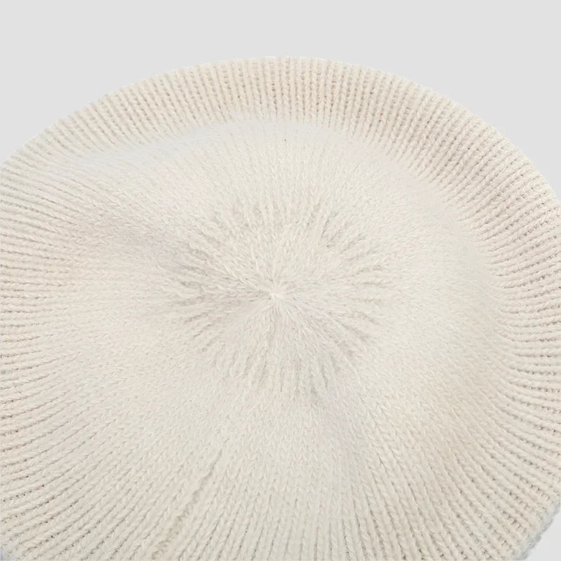 Cream-colored knitted beret.