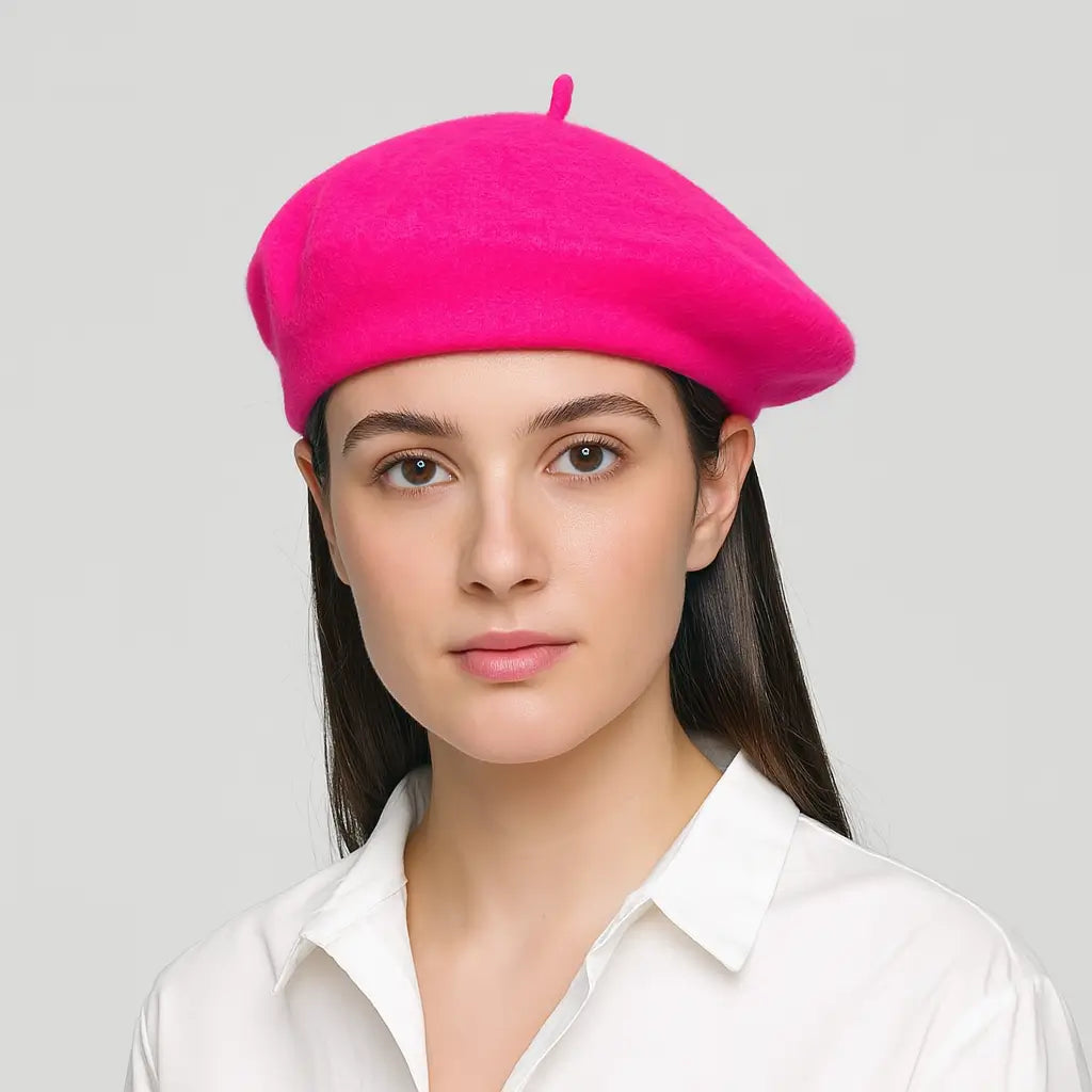 Woman wearing a bright pink beret against a plain background