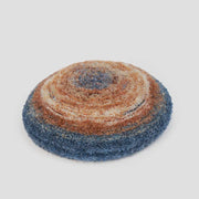 Round, textured, blue and brown cushion.