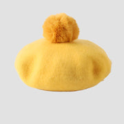 Yellow beret with a fluffy pompom.