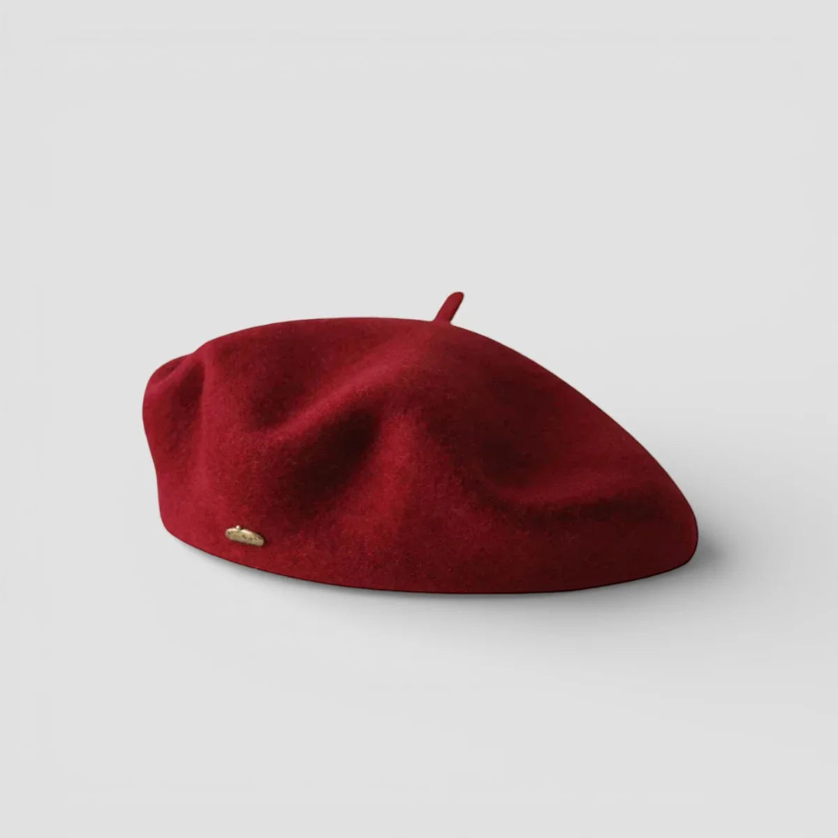 Rich red wool beret for women with gold emblem and top button
