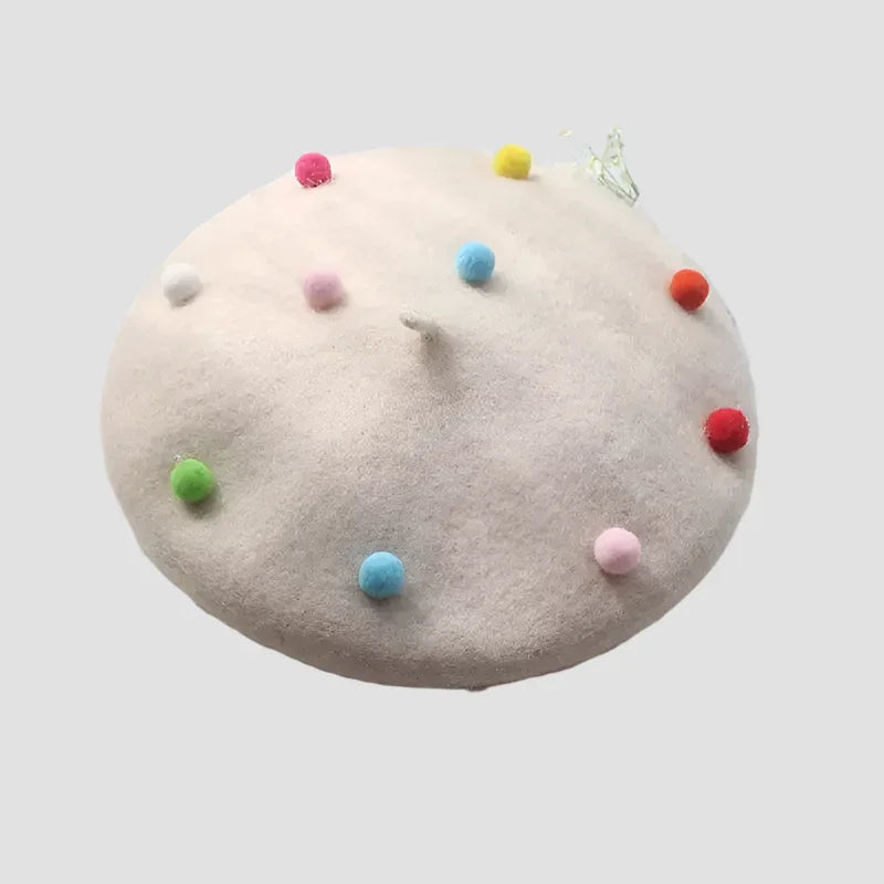 Cream-colored beret with colorful pom-poms.