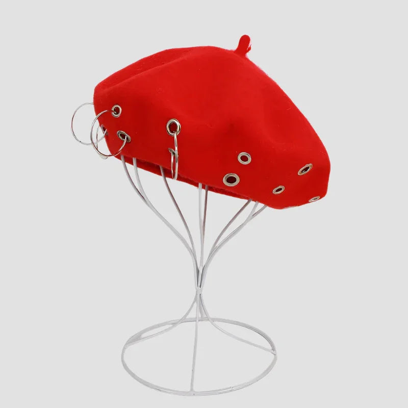 Red beret with silver grommets and hoop earrings.